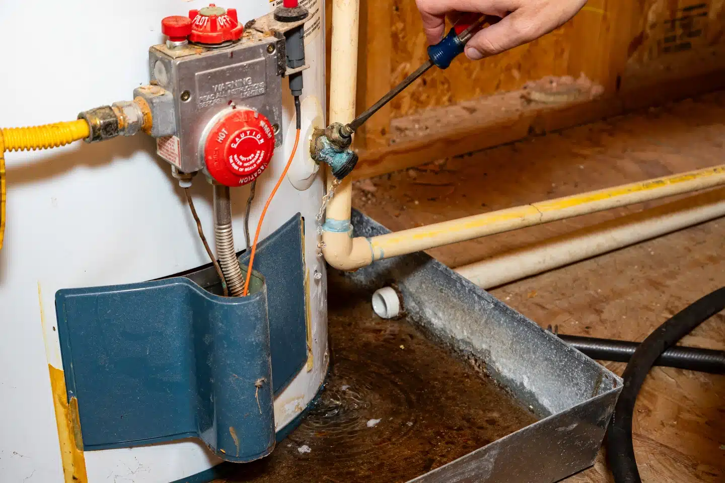 Leaking water heater being serviced in a Dallas home